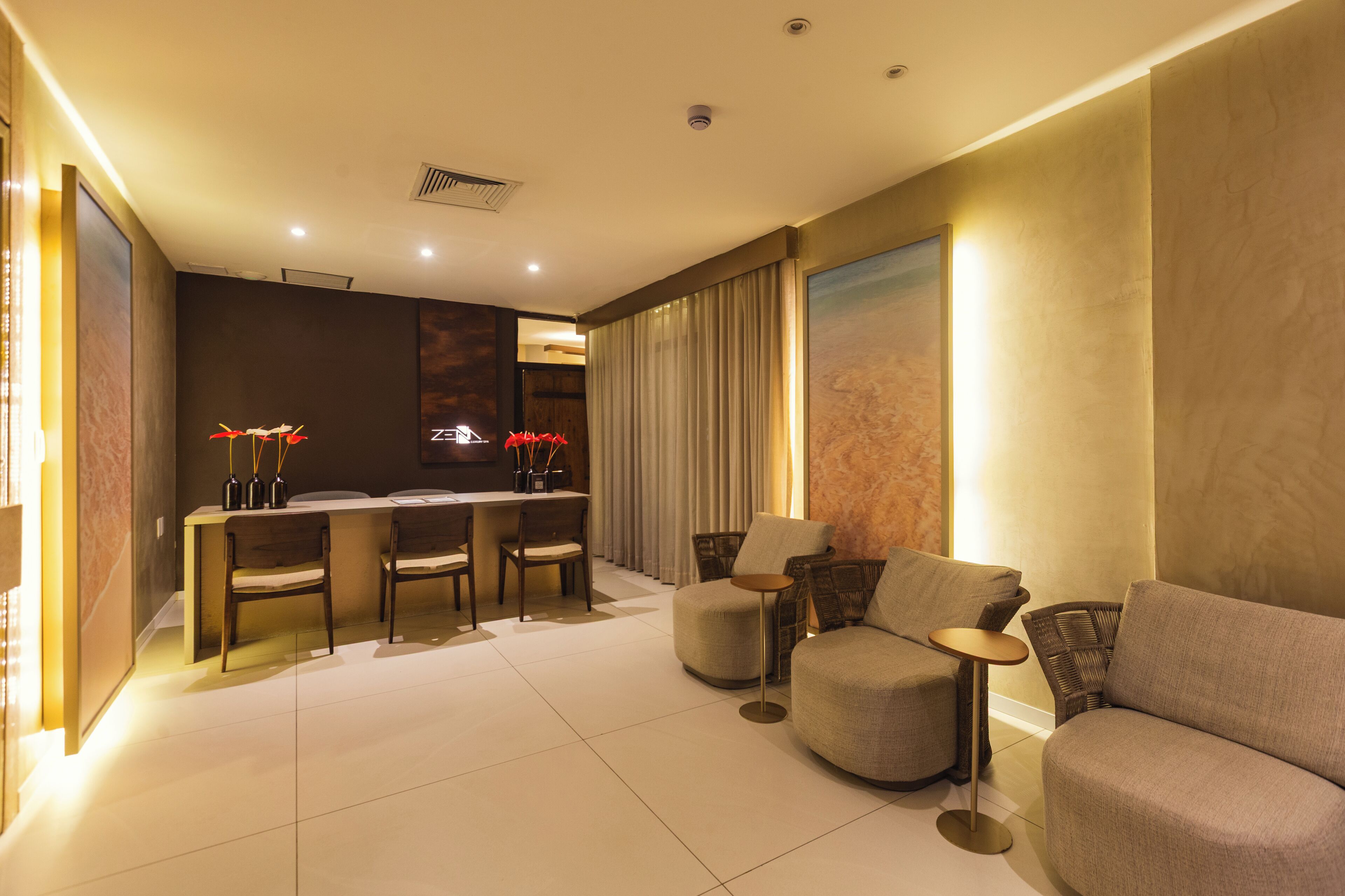 A modern living room with a dining area, featuring a sofa, chairs, a small table, and a decorative vase.