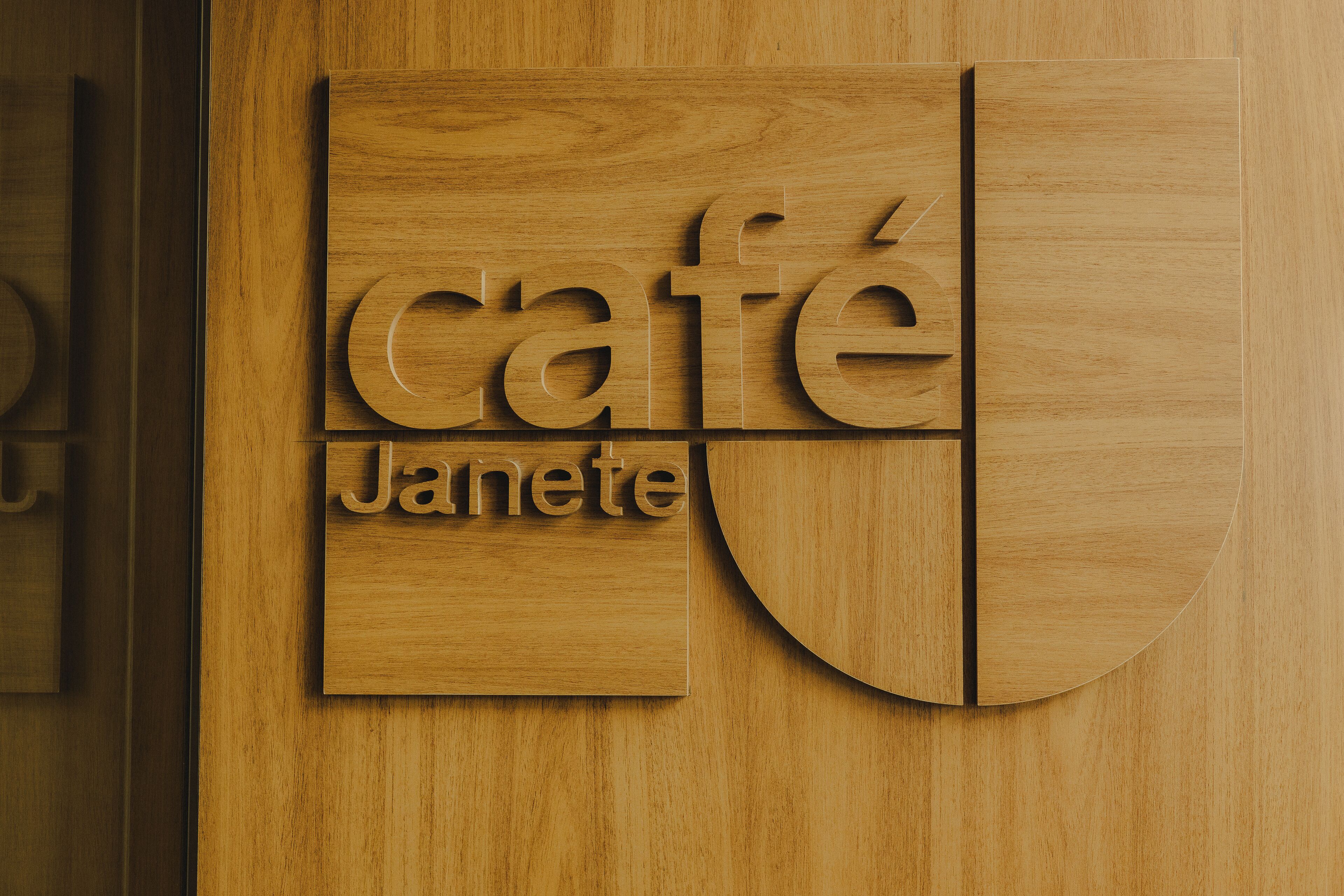 A wooden wall with a sign that reads "café Janete."