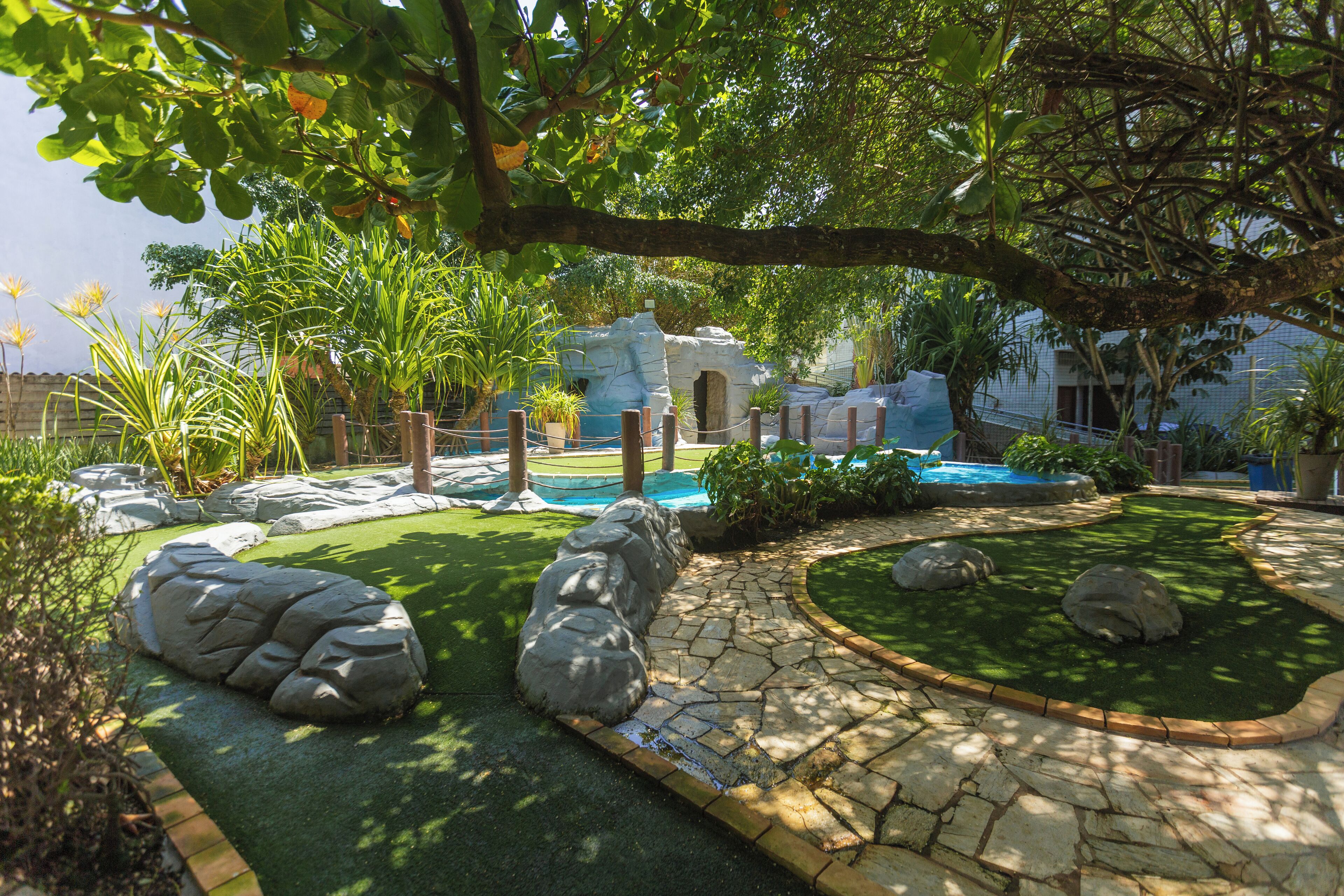 A landscaped garden with a pool, stone pathway, and large rocks.