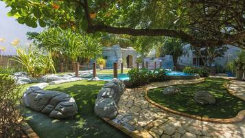 A landscaped garden with a pool, stone pathway, and large rocks.