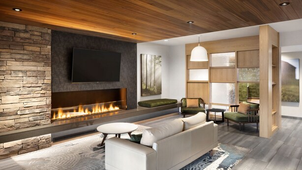A modern living room with a stone fireplace, a flat-screen TV, a sofa, and a dining area with a table and chairs. - Fairfield Inn & Suites by Marriott West Kelowna (West Kelowna)