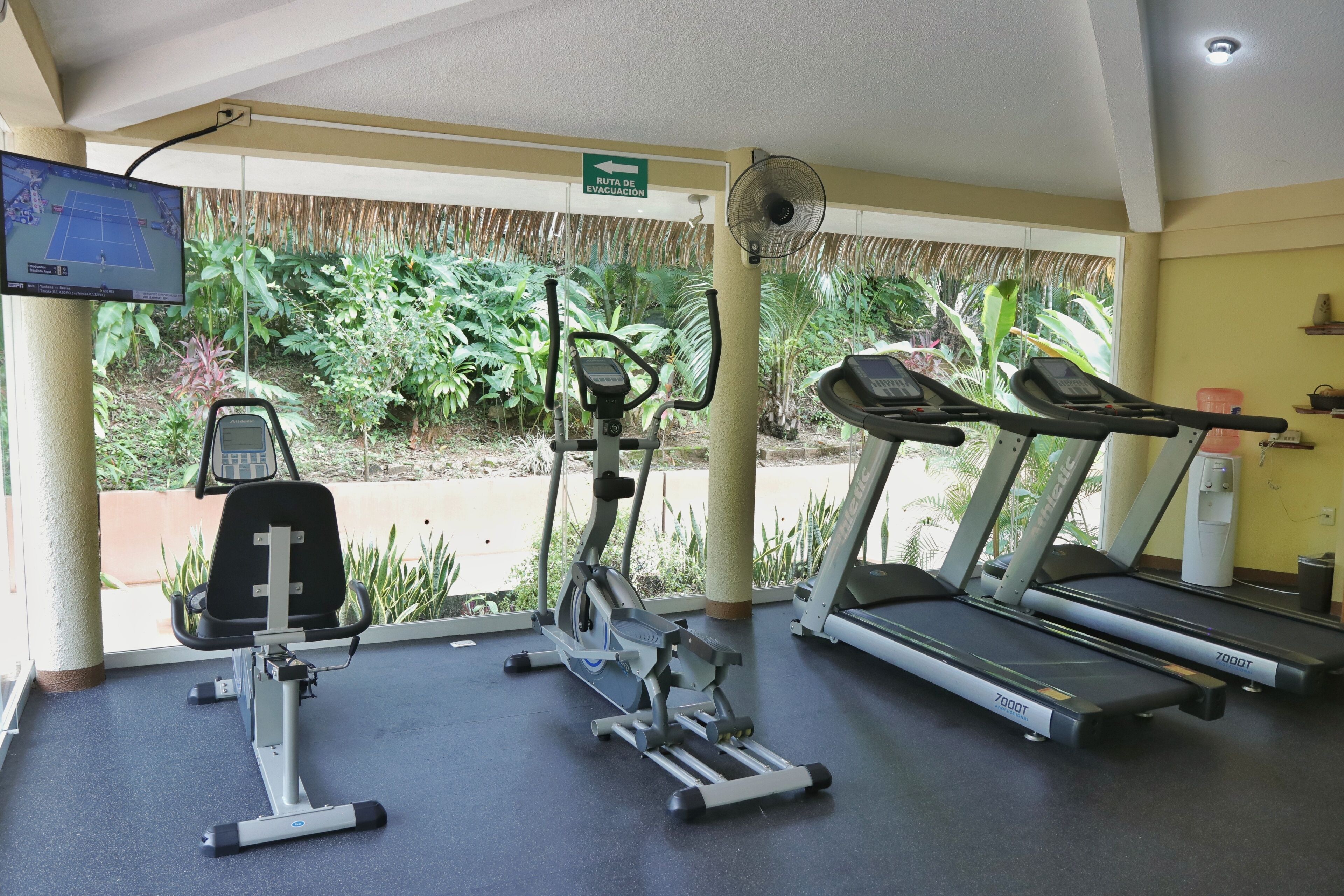A gym with treadmills, an elliptical, and a stationary bike.