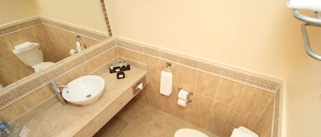 Un baño con lavabo, inodoro y espejo.