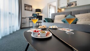 A dining table with a martini glass and a plate of food in a hotel room.