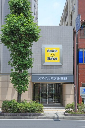 Un hôtel avec une enseigne indiquant « Smile Hotel » et une autre enseigne dans une langue différente.