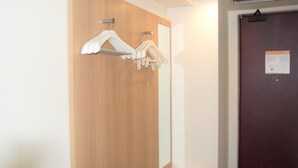 Una puerta de madera con un espejo y dos perchas blancas.
