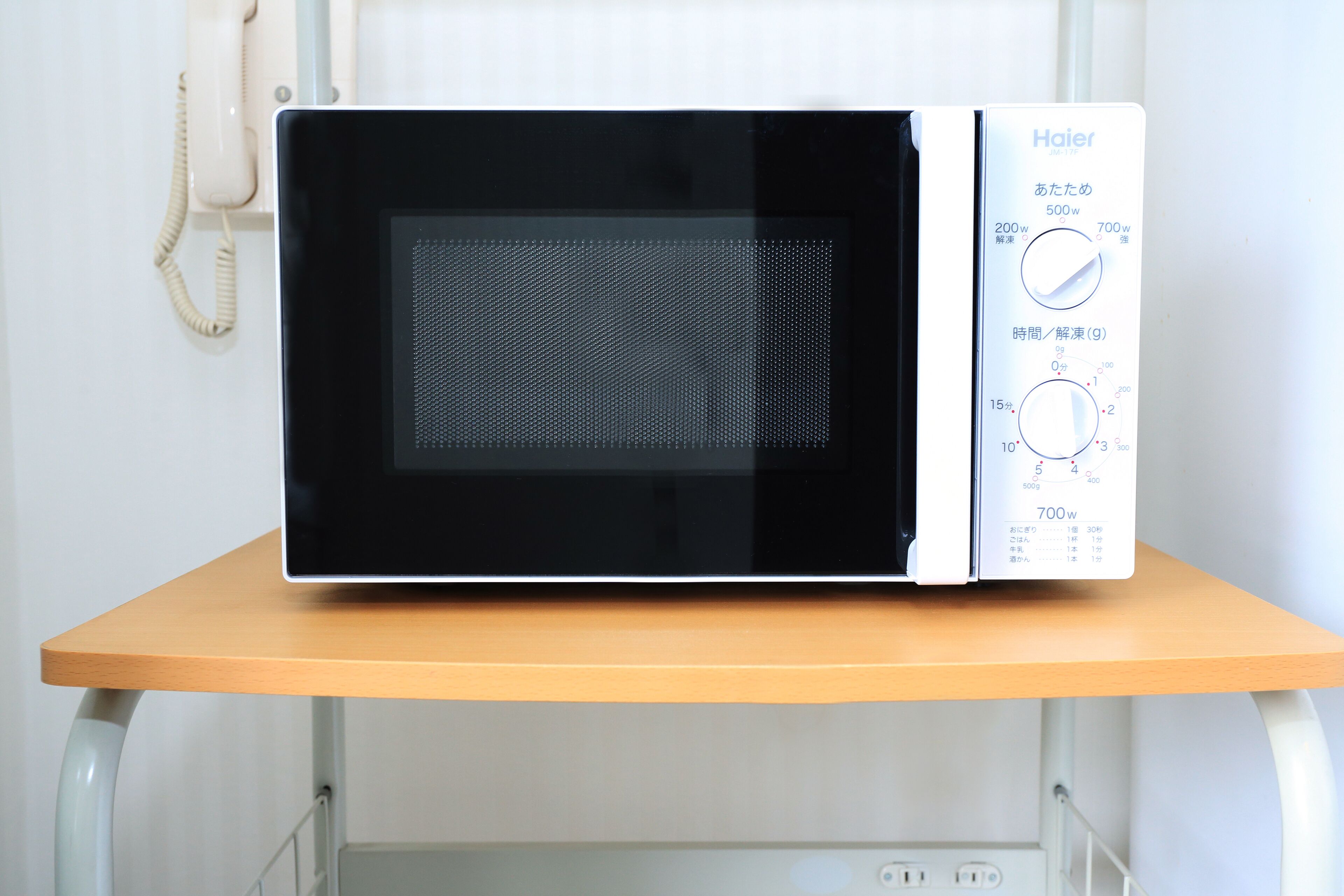 A microwave oven with a control panel on a wooden table.