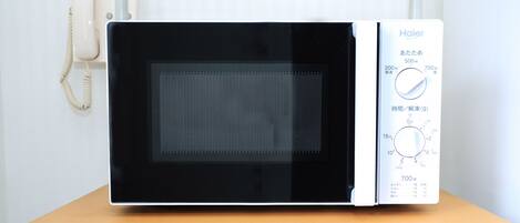A microwave oven with a control panel on a wooden table.