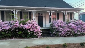 A two-story house with a porch, a front door, and a mailbox. - The Queen Anne Inn (Augusta)