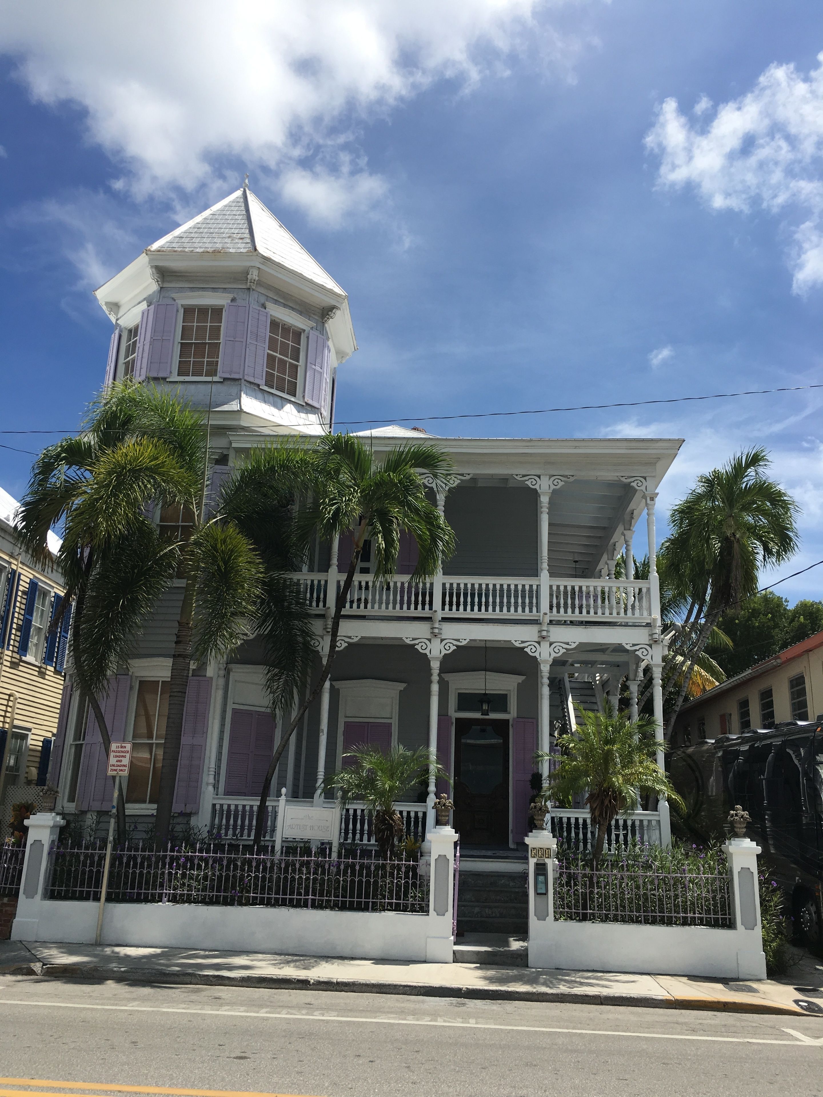 A two-story building with a balcony and a tower.