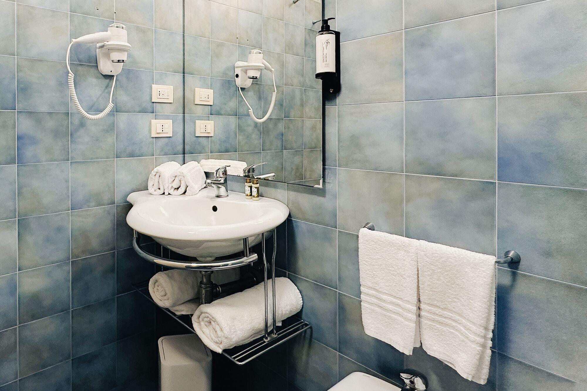 A bathroom with a sink, towel rack, and a mirror.