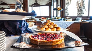 Een buffet met diverse gebakjes en desserts, waaronder een grote taart met bessen.
