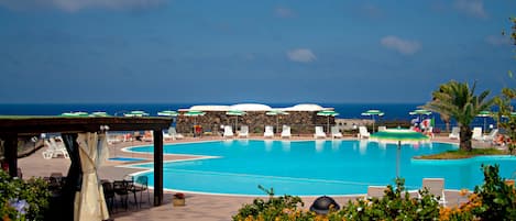 Piscine extérieure, parasols de plage, chaises longues