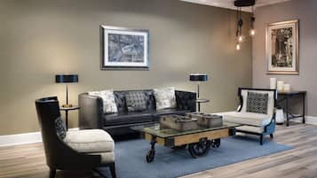 A living room with a sofa, two armchairs, a coffee table, and a rug.