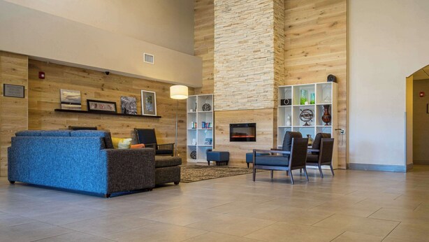 A spacious living area with a fireplace, a blue sofa, and a coffee table. - Country Inn & Suites by Radisson, Doswell (Kings Dominion), VA (Doswell)