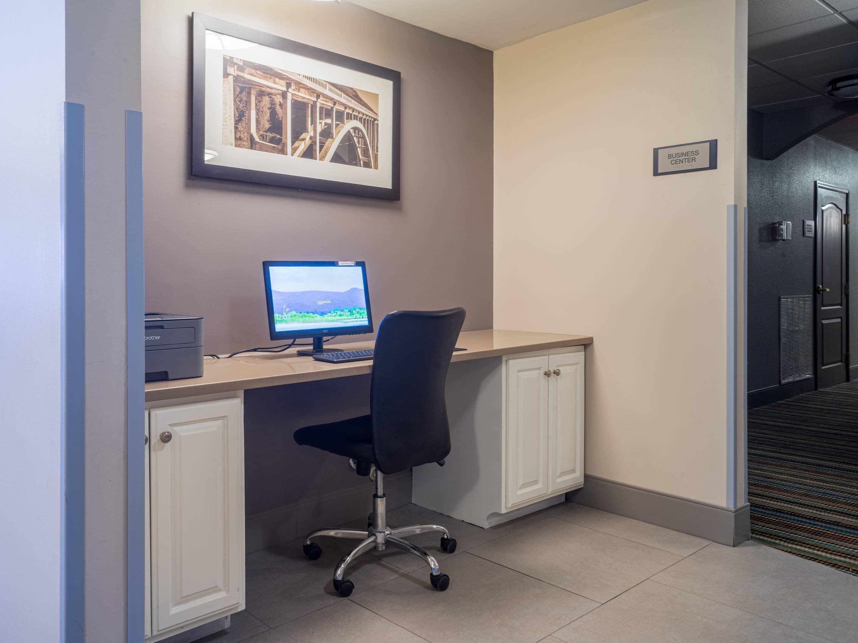 A workspace with a desk, computer, chair, and cabinets.