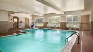 A large indoor swimming pool with clear blue water, surrounded by windows offering views of greenery. - Country Inn & Suites by Radisson, Doswell (Kings Dominion), VA (Doswell)