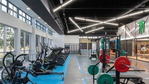A gym with exercise equipment, weightlifting stations, and large windows. - Quórum Cordoba Hotel - Resort Urbano (Córdoba)