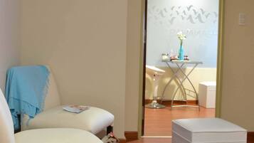 Relax in a cozy space with a comfortable armchair, ottoman, and modern amenities.