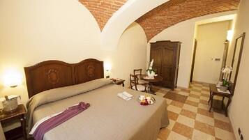 Ein Hotelzimmer mit Bett, Schreibtisch, Stuhl und Kleiderschrank.