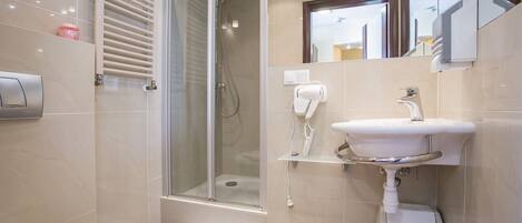 Ein modernes Badezimmer mit einer Duschkabine aus Glas, einem weißen Waschbecken und einer Toilette.