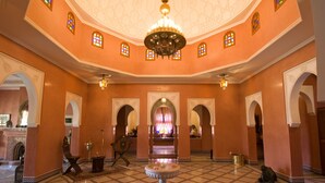 A lobby with a fountain, arches, and a chandelier. - Dar Kantzaro (Marrakech)