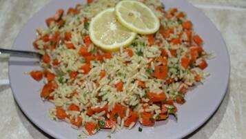 A plate of rice with carrots and lemon slices.