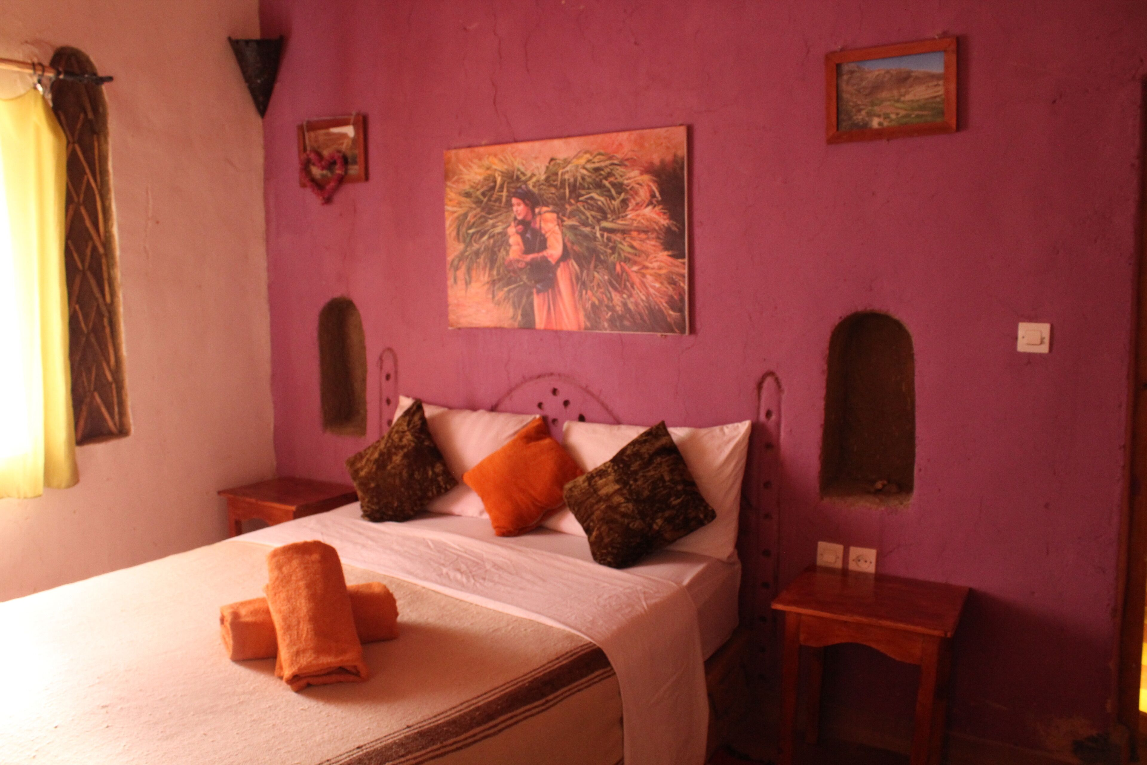Una stanza con un letto, un quadro e un tavolino.