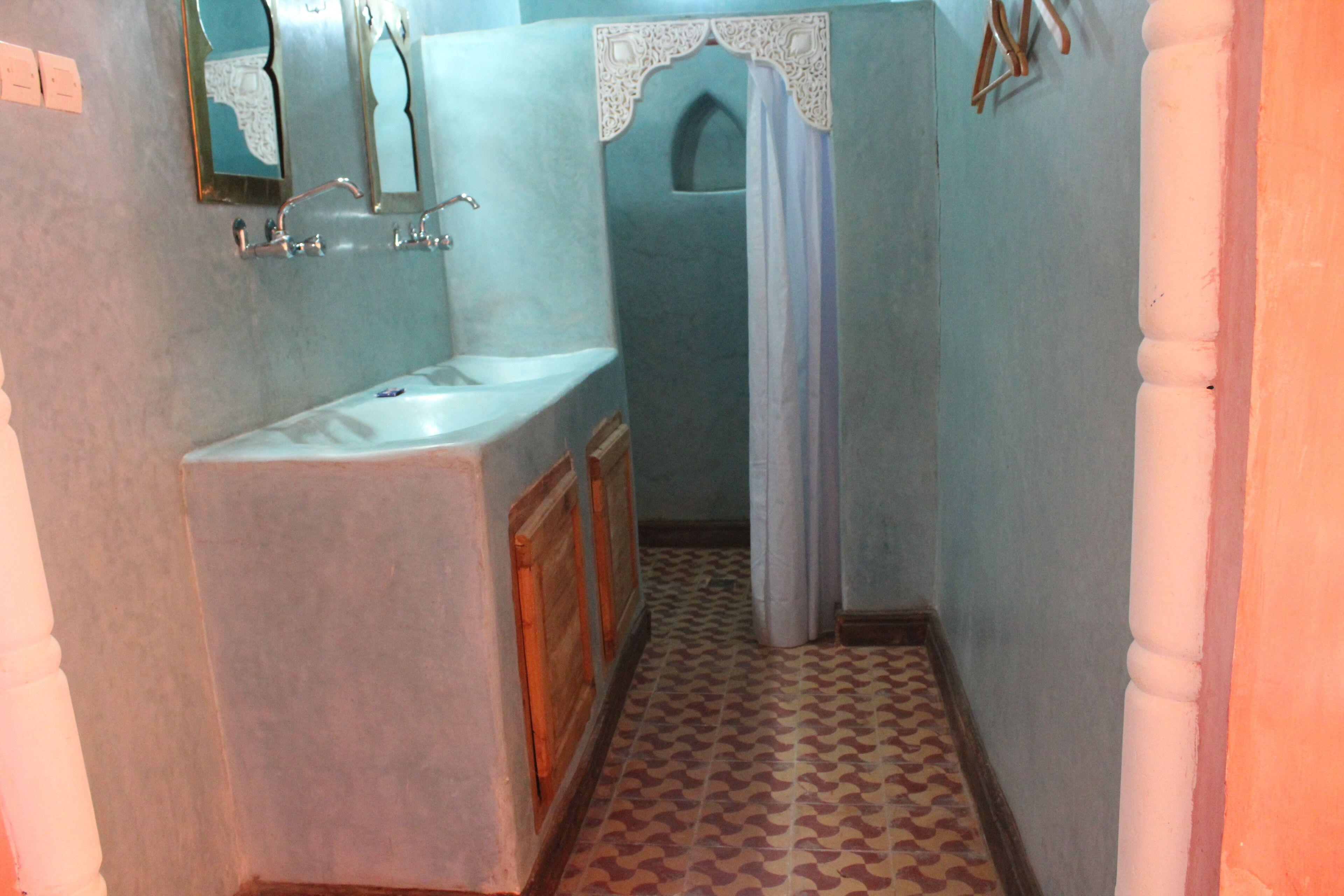 Un bagno con lavandino, specchio e tenda per la doccia.