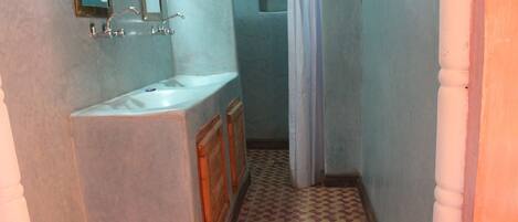 Un baño con lavabo, espejo y cortina de ducha.