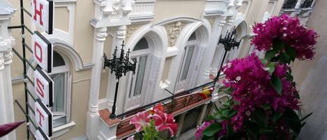 A hotel facade with ornate architectural details, including arched windows and decorative moldings.