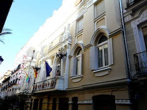 Fachada de hotel de estilo arquitectónico clásico, con ventanas de arco y molduras decorativas.