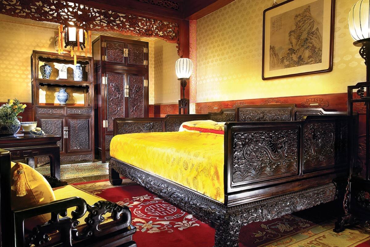 Une chambre traditionnelle avec un lit en bois, un bureau et une chaise.
