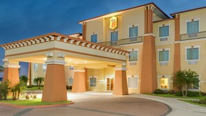 A hotel with a prominent entrance, multiple floors, and a well-lit facade. - Super 8 by Wyndham Hidalgo/McAllen Area (Hidalgo)