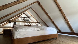 A bedroom with a wooden bed in a sloped ceiling room. - Statthotel (Zürich)