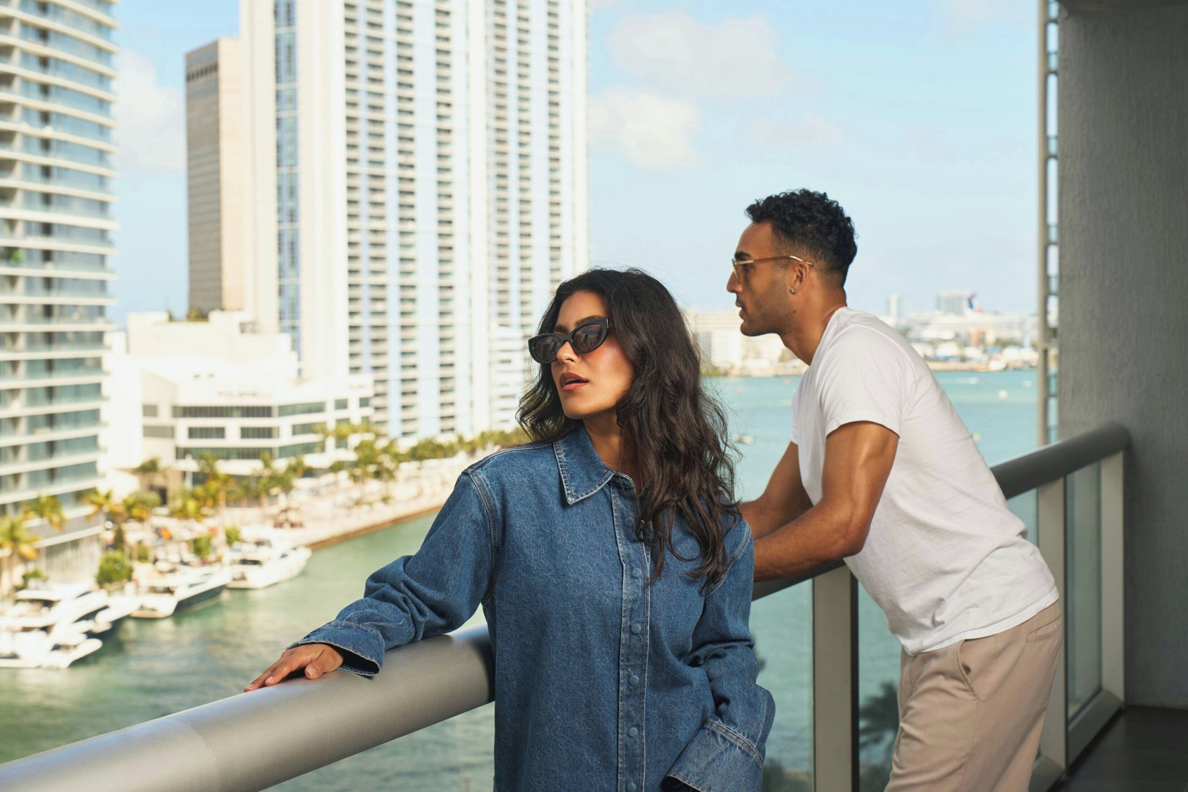 A balcony with a city view, a railing, and a body of water with boats.