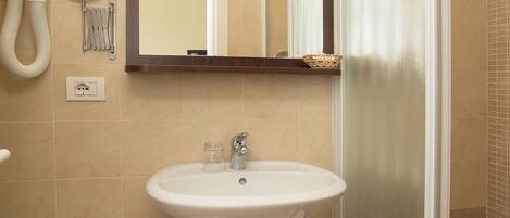 Un baño con lavamanos, espejo e inodoro.