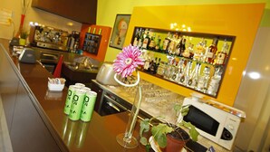 A bar area with a counter, a flower in a glass, and a microwave. - Hotel Alibì (Rimini)
