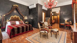 A luxurious bedroom with a four-poster bed, ornate curtains, a chandelier, and a traditional rug. - Hotel Ca' Alvise (Venice)