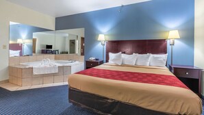 Ein Hotelzimmer mit einem großen Bett, einem separaten Badezimmer mit Badewanne und zwei Nachttischlampen.