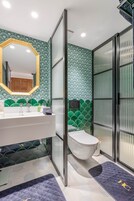 A bathroom with a white sink, a mirror with a golden frame, and a toilet.
