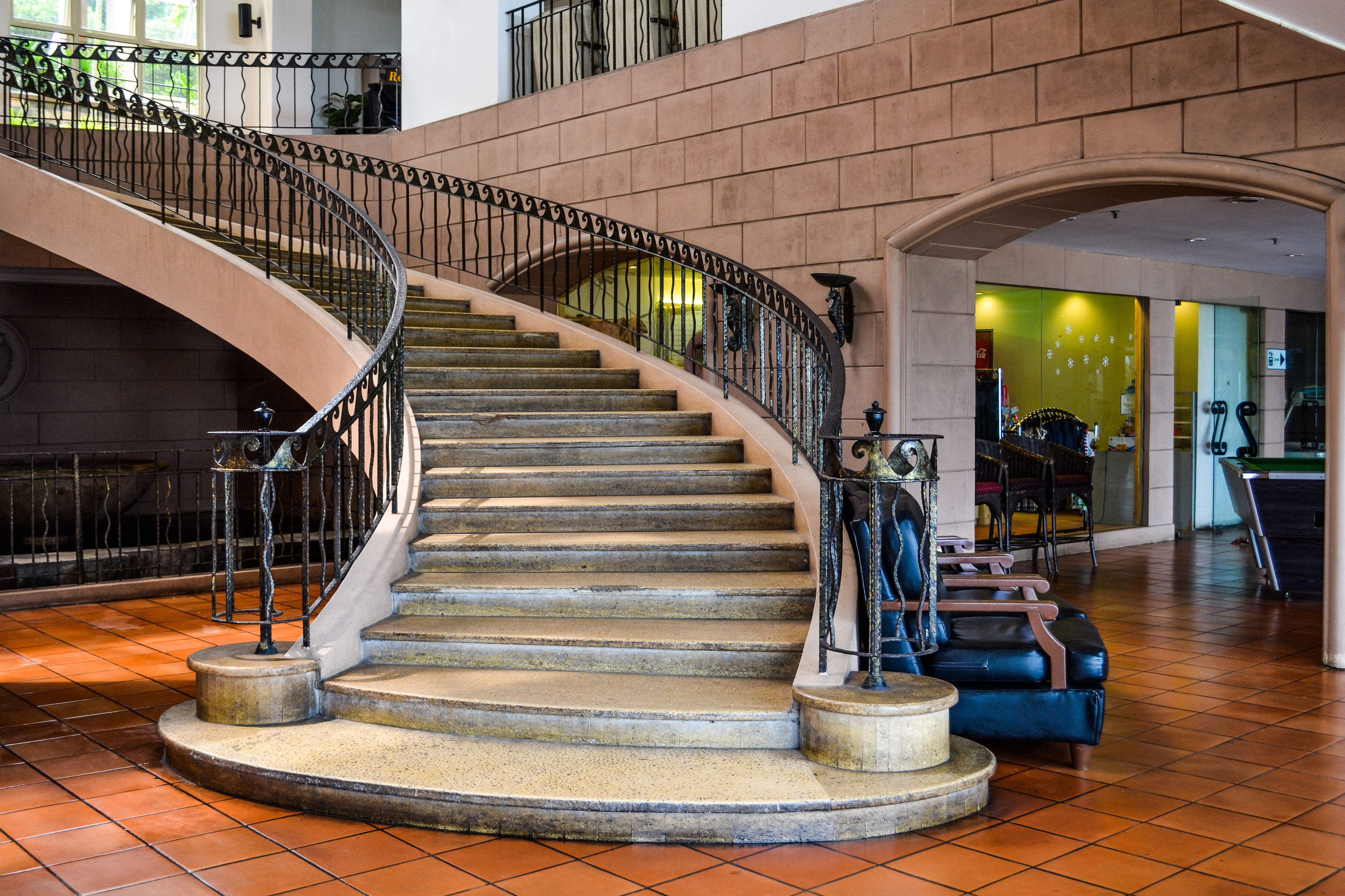Una imponente escalera con barandilla curva que lleva a un piso superior.