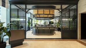 A modern interior with a central bar area, surrounded by a decorative black partition with vertical slats. - Novotel Singapore Robertson Quay (Singapore)