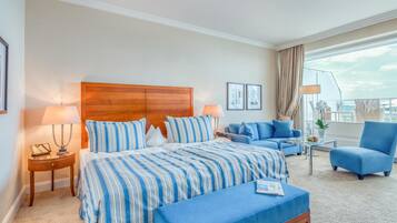 Habitación de hotel con una cama grande, un sofá, una silla y un balcón con vistas.