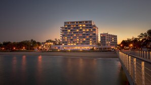 Un hotel de varios pisos con un diseño arquitectónico moderno, situado cerca de la costa.