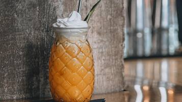A glass with a textured design and a straw, placed on a reflective surface.