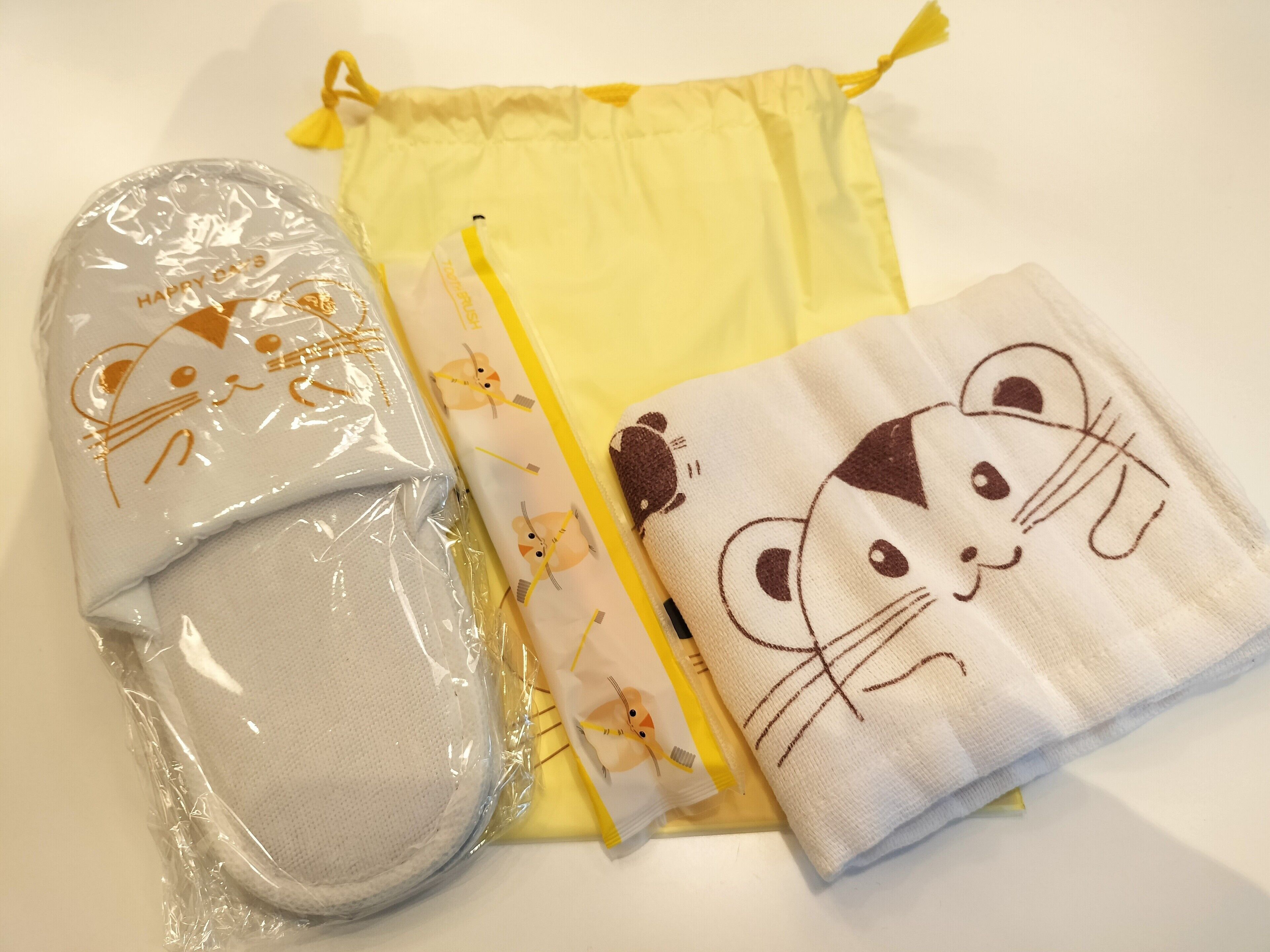 Toallas bien dobladas y una bolsa con cordón, probablemente para uso en hotel.