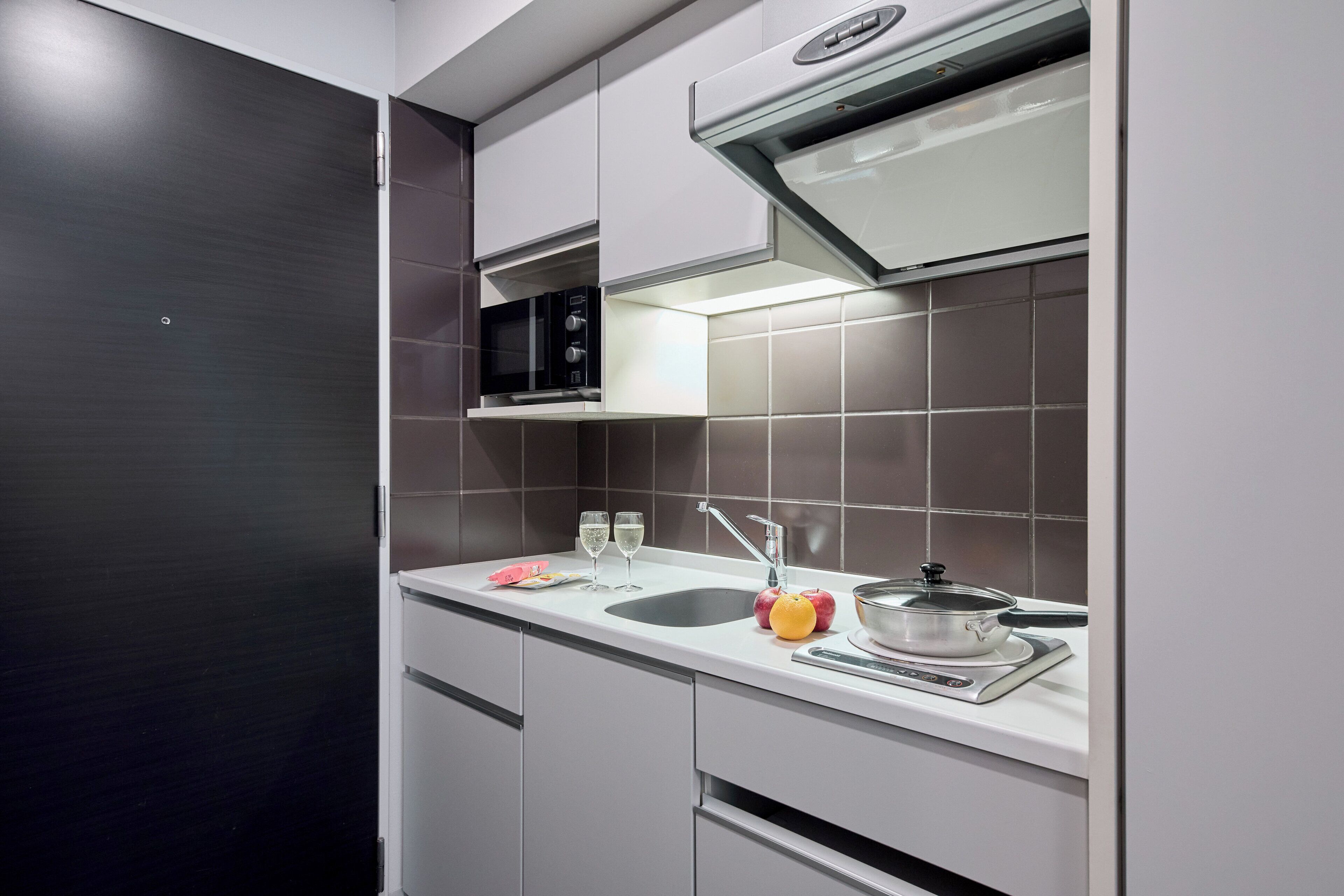A modern kitchen with a microwave, sink, and stove.
