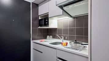 A modern kitchen with a microwave, sink, and stove.