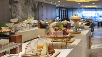 Disposição de buffet com diversos alimentos e um arranjo decorativo.
